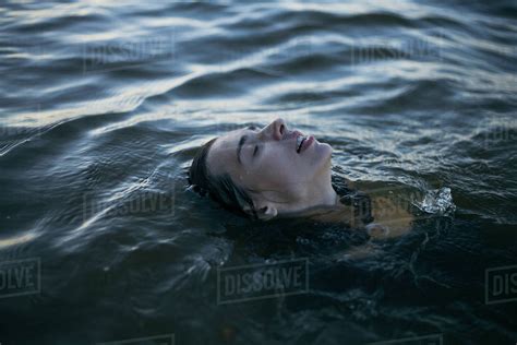 Caucasian Woman Floating In Ocean With Eyes Closed Stock Photo Dissolve