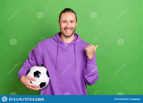 Photo Of Sportive Guy Hold Soccer Ball Point Finger Empty Space Present