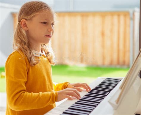 Portrait Of Pretty Little Girl Having Piano Lesson At Modern White E