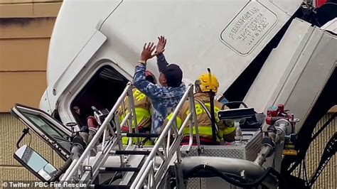 Dramatic Moment Firefighters Rescue Truck Driver From Dangling Cab