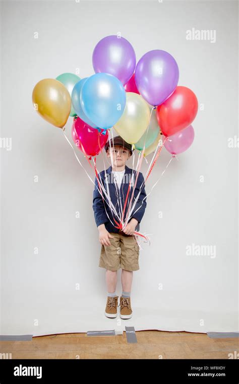 Boy Holding Colorful Balloons Against White Background Stock Photo Alamy