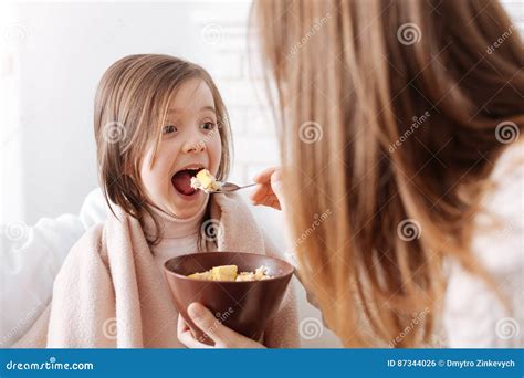 Cheerful Nice Little Girl Enjoying Breakfast With Mother Stock Photo