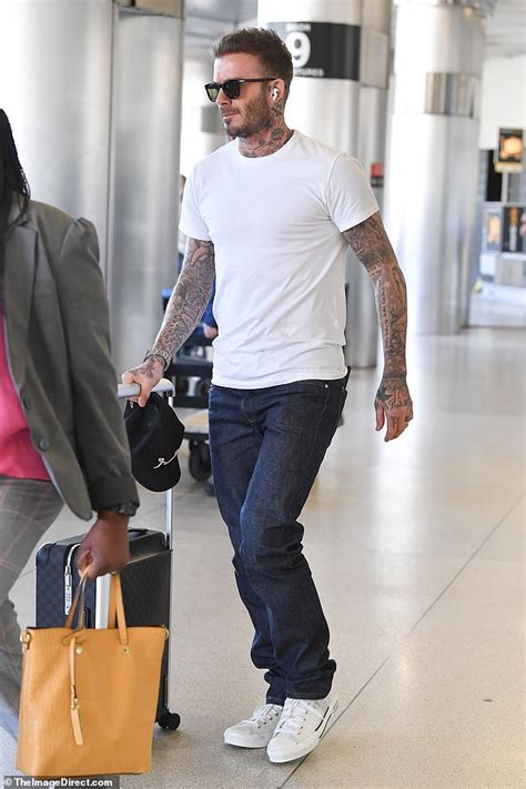 Cool & handsome is my destiny! David Beckham displays his heavily-tatted arms in a plain ...