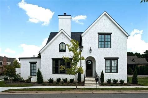Did you grow up dreaming of a classic brick house with a white picket fence? white painted brick house black exterior window trim ...