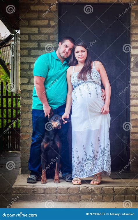 Pregnant Woman In White Dress Her Husband And Doberman Stock Image