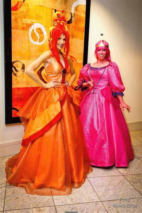 Two Women Dressed Up In Costume Standing Next To Each Other On The