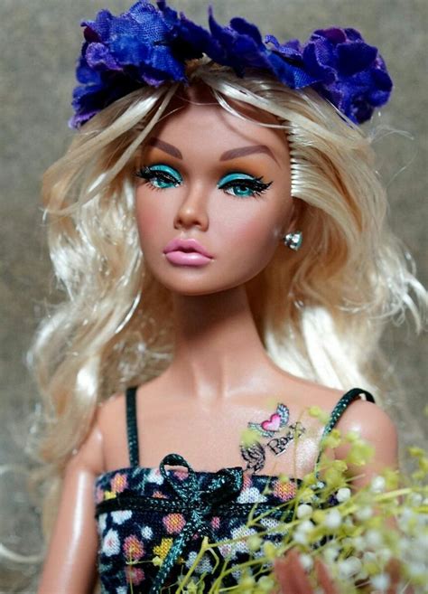 A Close Up Of A Barbie Doll With Flowers In Her Hair And Blue Eyeshades
