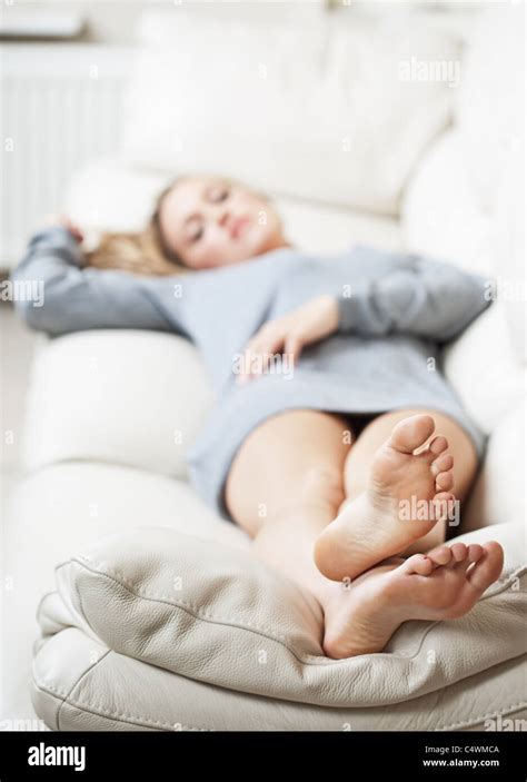 Barefoot Young Woman Lying On Sofa Shallow Depth Of Field Focus On