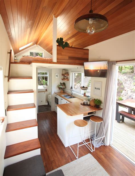A Kitchen And Dining Area In A Tiny Home With Wood Floors White Walls