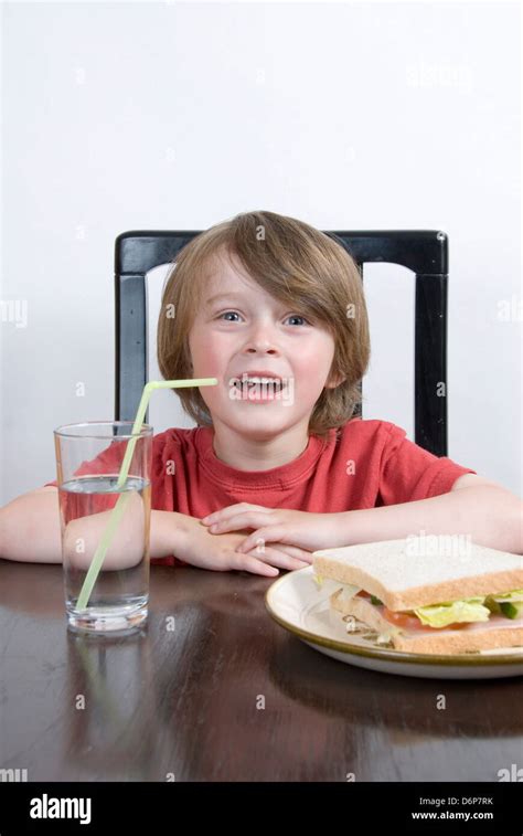 Smiling Young Boy Sitting At The Table With His Lunch A Salad Sandwich