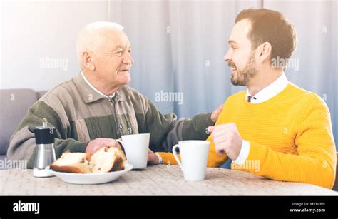 Anciano Padre E Hijo Juntos Desayunando En La Mesa Y Amable Comunicarse