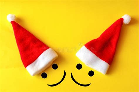 Two Merry Christmas Smiles In Santa Claus Hats On Yellow Background