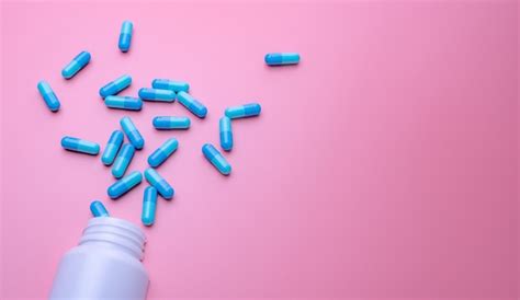 Premium Photo Blue Capsule Pills Spread Out Of White Plastic Drug