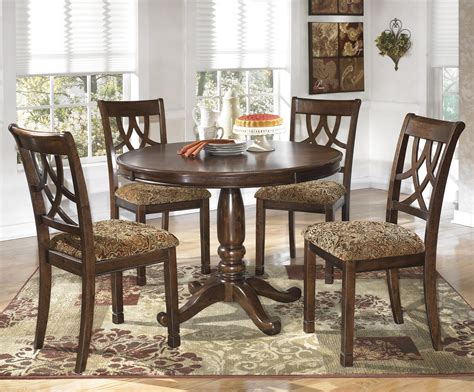 This new classic dining table set comes with four matching solid wood dining chairs. Signature Design by Ashley Lila 5-Piece Cherry Finish Round Dining Table Set | Rotmans | Dining ...
