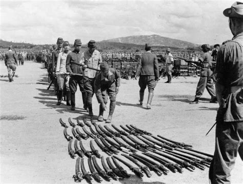 A Long Line Of Japanese Officers Wait To Surrender Their Swords To The