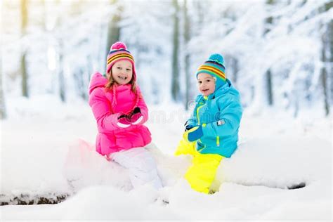 Kids Playing In Snow Children Play Outdoors In Winter Snowfall Stock