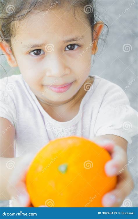 A Cute Girl Is Giving An Orange Stock Image Image Of Orange Charity