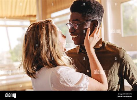 Beautiful Interracial Couple Looking Each Other With Love While Standing Indoors Romantic Man