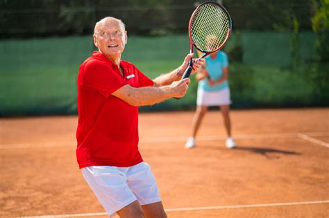 Concentrated Senior Tennis Player Focusing At Ball Back Hand Stock