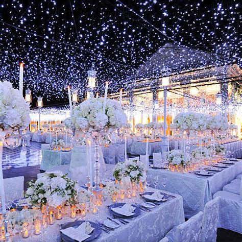 the tables are set with white flowers, candles and centerpieces for an