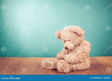 Sad Teddy Bear Toy Sitting Alone On Wooden Floor In Front Mint Blue