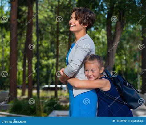 Excited Schoolgirl Hugs Mom Behind Her Back The Girl Missed Her Mother Very Much Stock Image