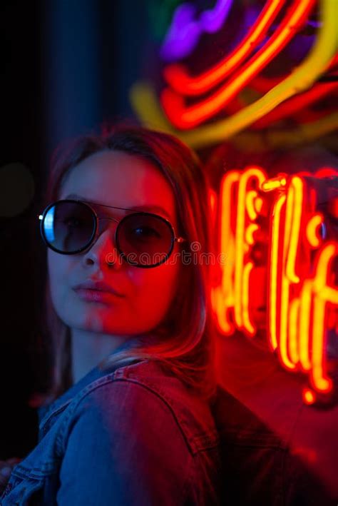 Creative Portrait Of A Girl In Neon Lighting With Glasses Stock Photo
