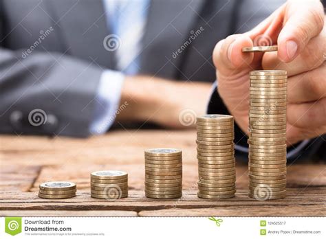 Businessman Stacking Coins In Increasing Order On Table Stock Image