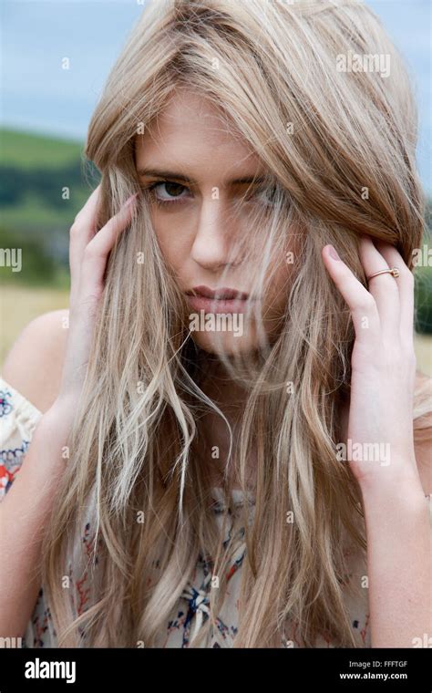 Portrait Of A Beautiful Girl With Long Blonde Hair Holding Her Head In