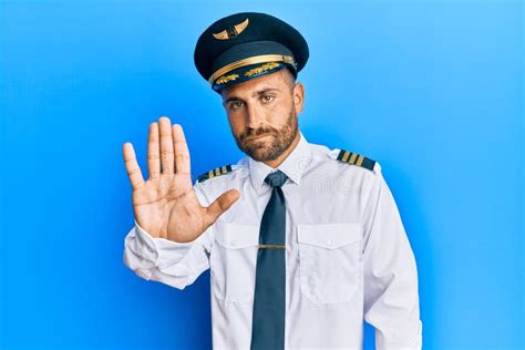 Handsome Man With Beard Wearing Airplane Pilot Uniform Doing Stop Sing