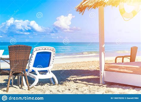 Sun Lounger Near Straw Umbrella Bed On The Sandy Beach By