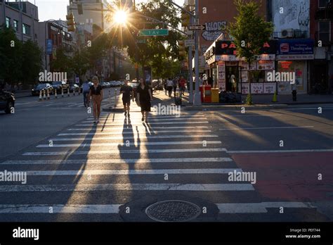 Pedestrians Crossing Street At Crosswalk By Sunset In Manhattan Ny
