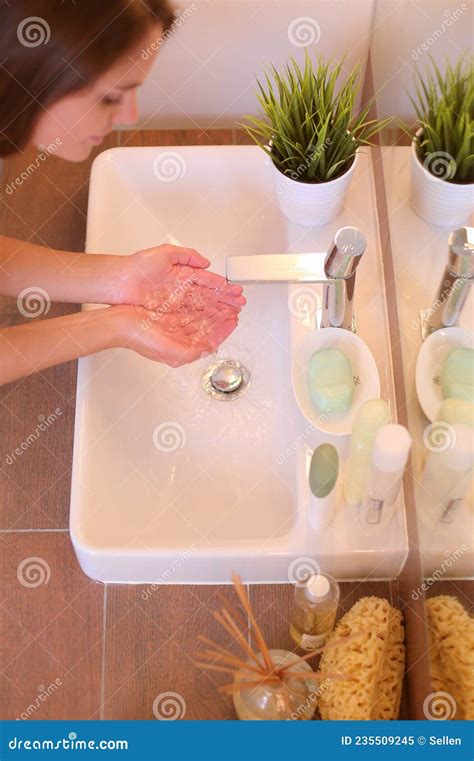 Young Woman Washing Her Face With Clean Water In Bathroom Stock Image