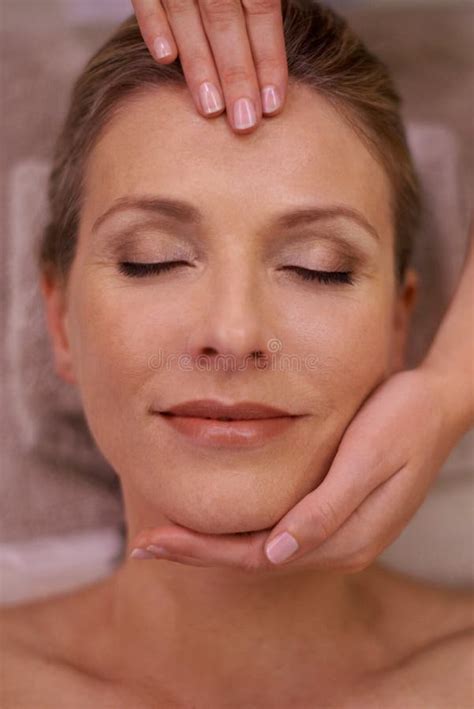 simply blissful cropped shot of a woman in a day spa getting a face massage stock image