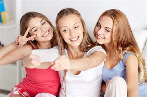 Tonåriga Flickor Med Smartphonen Som Hemma Tar Selfie Fotografering för