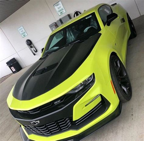 A Yellow Chevrolet Camaro Is Parked In A Garage