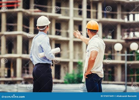 Architect And Builder Discussing At Construction Site Stock Image