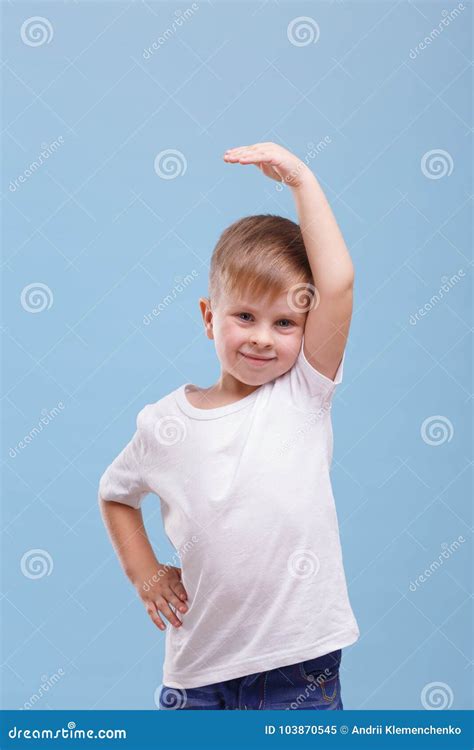 A Boy Raised His Hand Over His Head On A Blue Background Stock Image