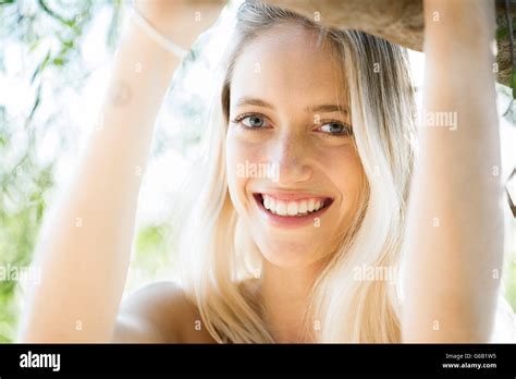 Young Woman Leaning Against Tree Branch Smiling Portrait Stock Photo