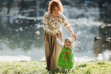 La Madre Con Su Hija Caminando Cerca Del Lago Foto Gratis