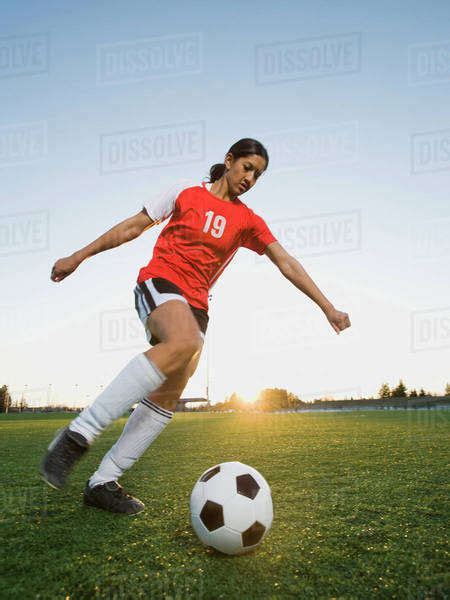 Mixed Race Woman Kicking Soccer Ball Stock Photo Dissolve