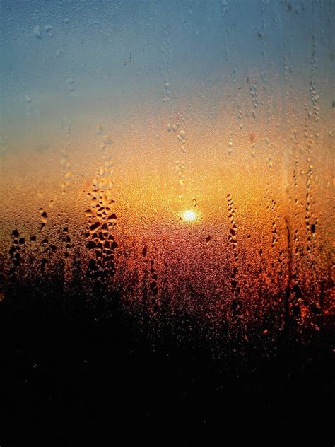 Water Drops On A Window Glass With Blurred Beautiful Sunset Sky Stock