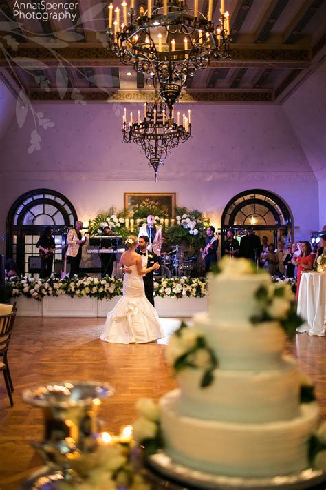 Bride And Grooms First Dance In A Ballroom With Their Wedding Cake In
