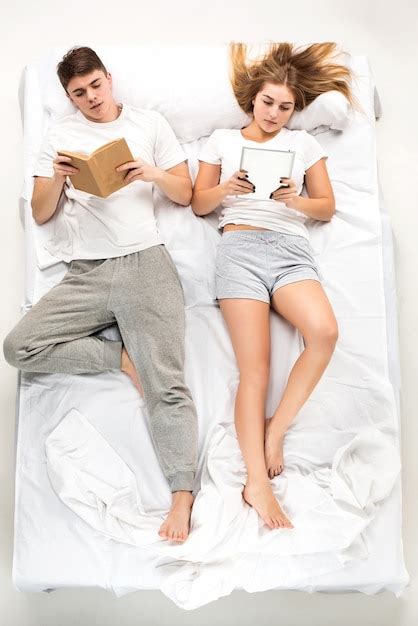 Free Photo The Young Lovely Couple Lying In A Bed With Books