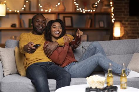 Joyful African American Couple Watching Tv Together At Home Stock Image