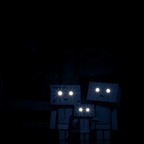 Two People Standing Next To Each Other In The Dark With Lights On Their