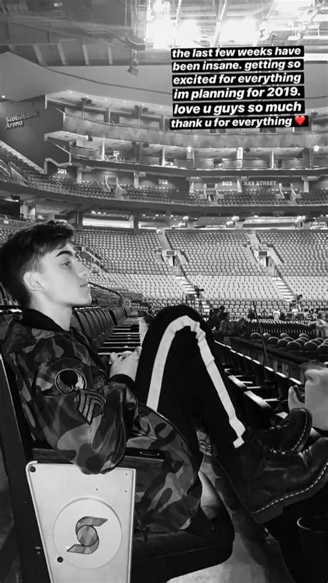 A Man Sitting On Top Of A Chair Next To An Empty Stadium Filled With People