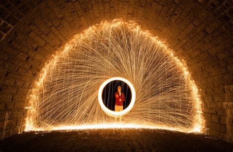 A Person Standing In Front Of A Tunnel Filled With Lights And Sparkles