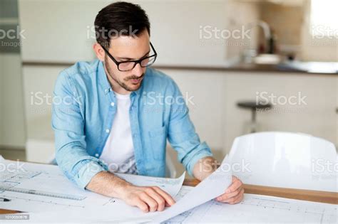 Portrait Of Adult Architect Working On Plans And Blueprints Stock Photo