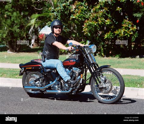 Man Riding Harley Davidson Motorcycle On Suburban Street Stock Photo